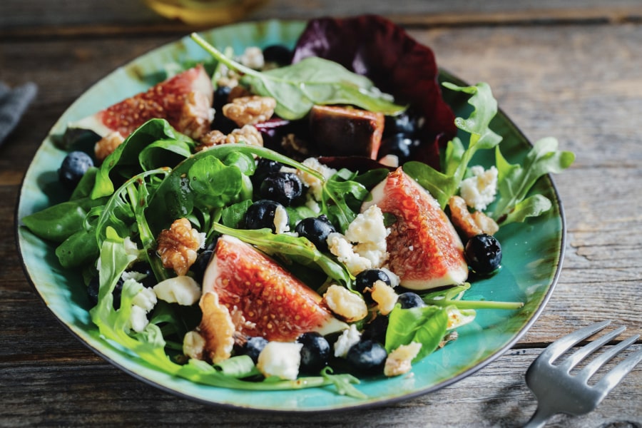 Hashimoto's Flare up - lifestyle changes through food showing a rich salad topped with nuts, olives, and guava - blog - Conscious Med